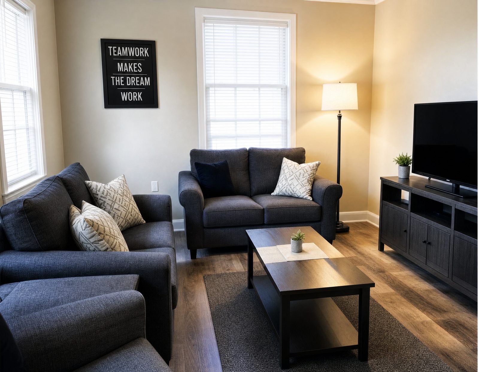 Living room with two sofas, a coffee table, floor lamp and television